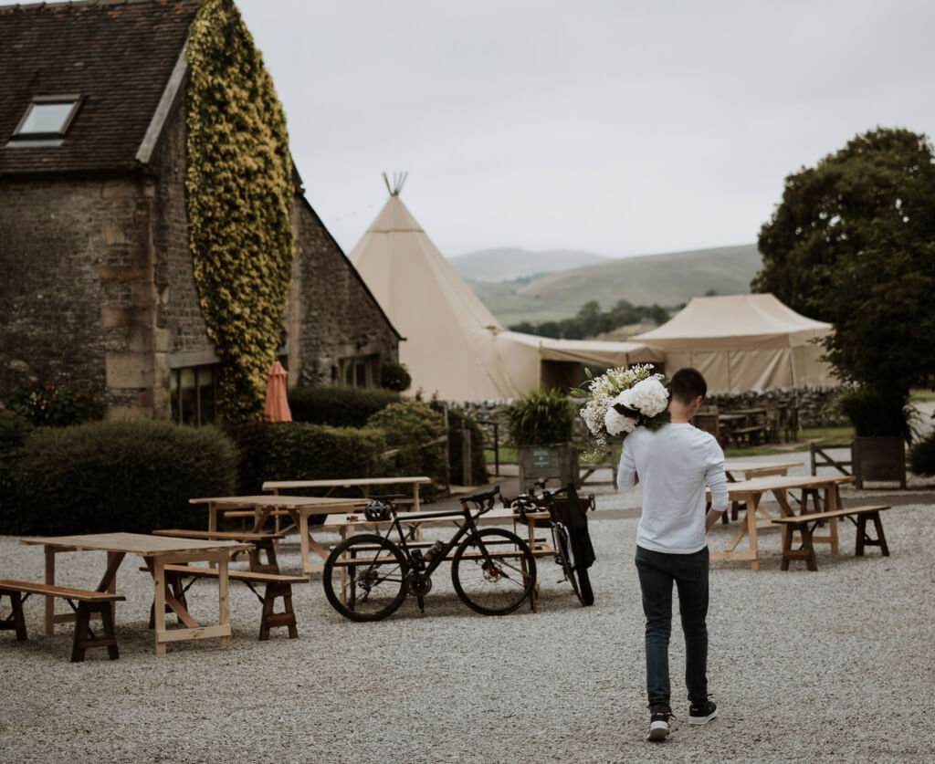 Man Carrying Flowers In The Courtyard At A Wedding Venue