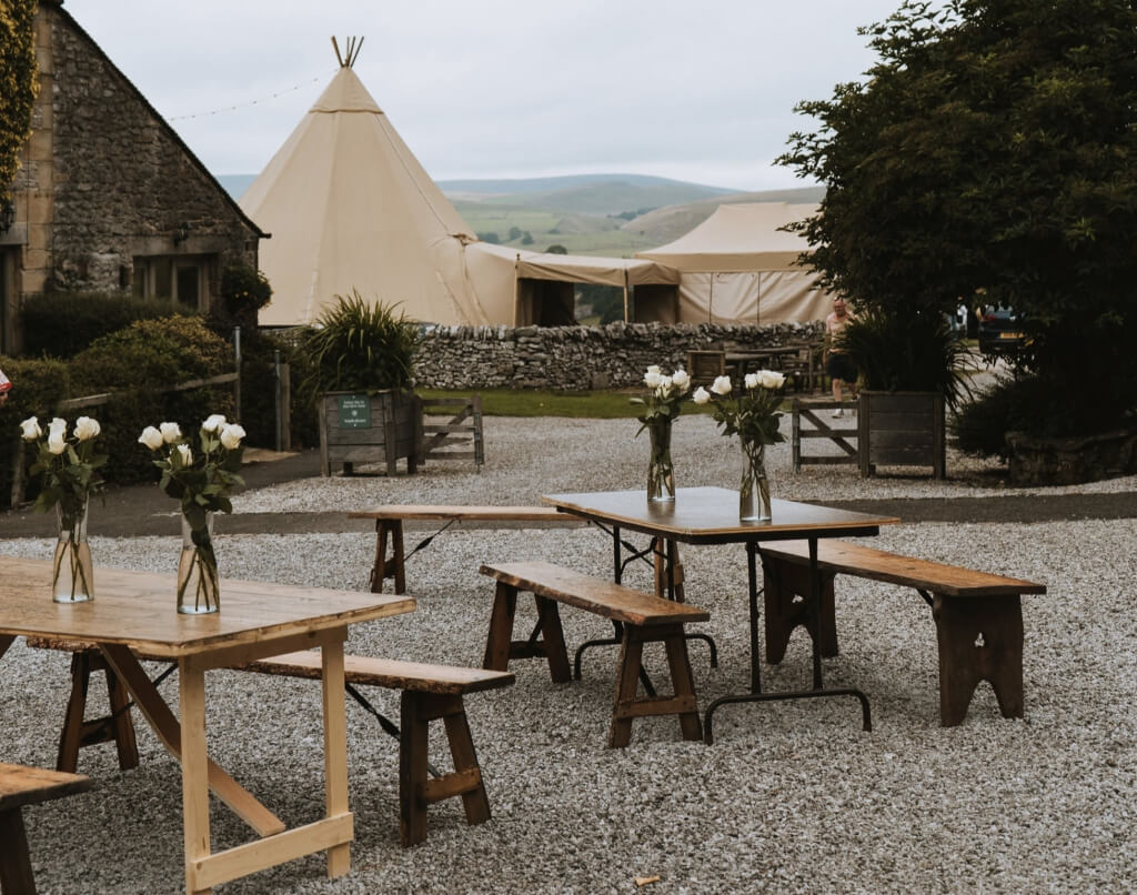 Courtyard With Tables And Benches Overlooking Tipi In The Background