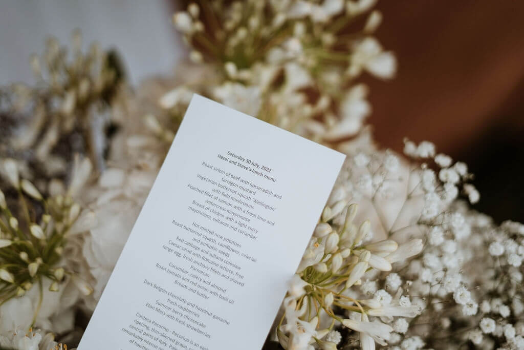 Wedding Menu With Flowers In The Background