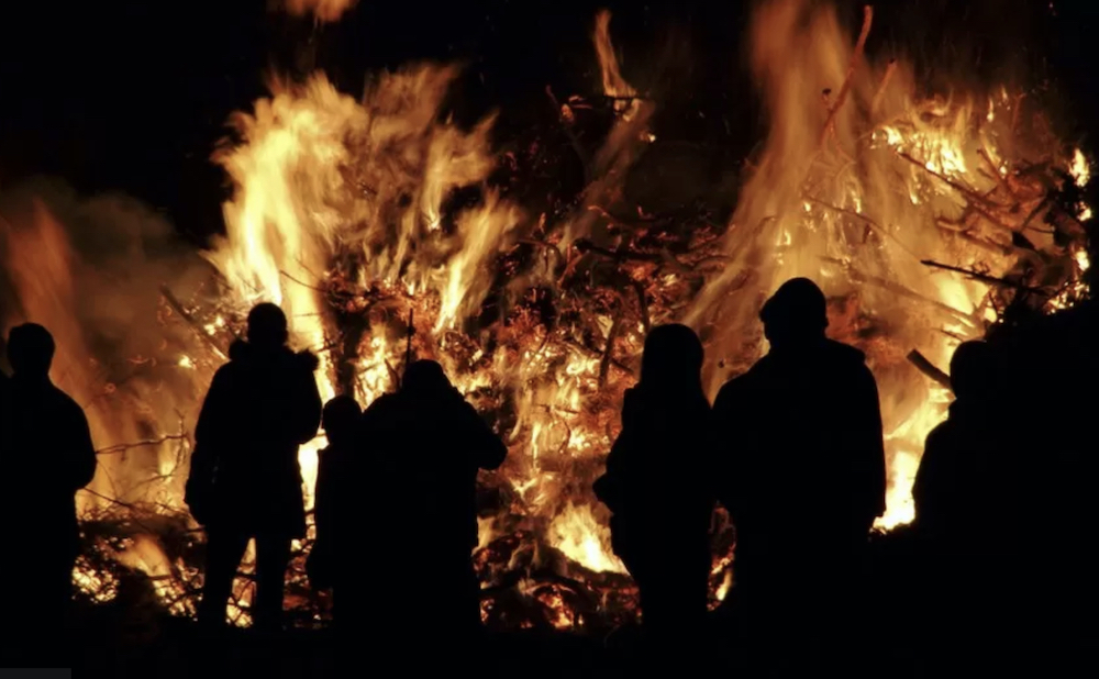 Picture Shows People Around A Bonfire